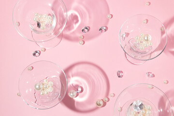 Christmas party creative layout with white pearls, diamonds and margarita and martini cocktail glasses on  pastel pink background. Retro fashion aesthetic party concept. New Year or Christmas idea.