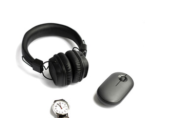 Isolated black headphones, computer mouse and wrist watch