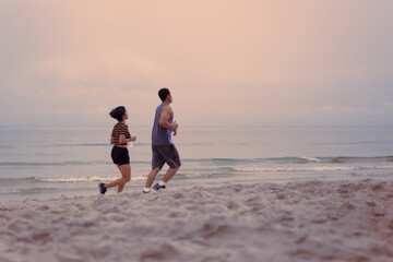 Couple jogging on the beach together health care concept.
