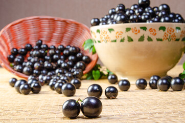 Jabuticaba, Jabuticabas freshly harvested in a bowl and baskets arranged on a straw mat, selective focus.