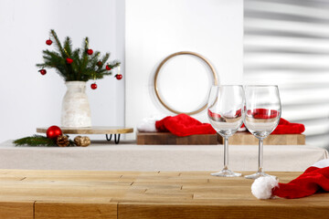 Wooden table with blank and golden Christmas accessories on the background of the wall with a shadow 