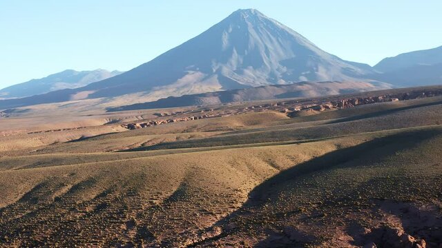 Aerial rising shot of the volcano Volcan Licancabur east of the town San Pedro de Atacama in the north of Chile in the Atacama desert at sunrise