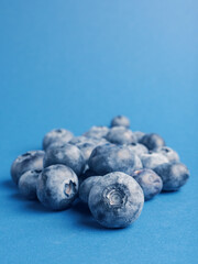A heap of blueberries on a blue backgrond with space for text, super food or healthy eating, fresh organic food