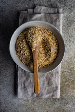 Overhead view of a bowl of milled oatmeal bran on a folded napkin