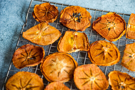 Sliced, Dried And Dehydrated Persimmon Fruit On A Cooling Rack