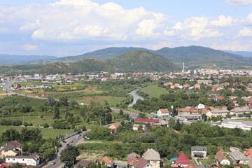 Fototapeta premium village in the mountains. Scenic view of the town in the mountains on a cloudy summer day.