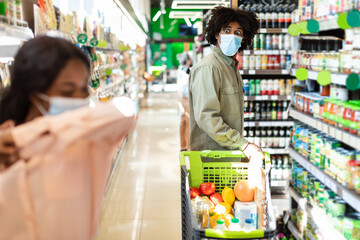 Scared African Man Looking At Sick Woman Coughing In Supermarket
