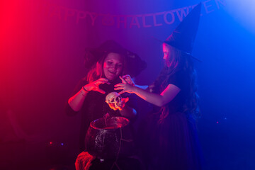 Two halloween witches making magic in halloween night. Magic, holidays and mystic concept.