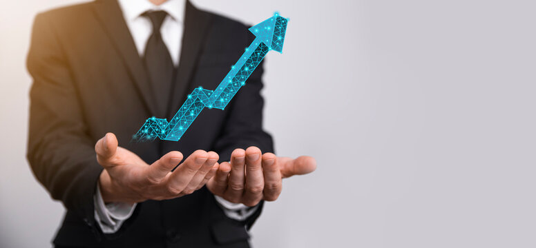 Businessman hold graph, arrow of positive growth icon.pointing at creative business chart with upward arrows.Financial, business growth concept.Low polygonal.increased sales, or increased value