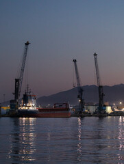 Fototapeta premium Grúas en el puerto al atardecer