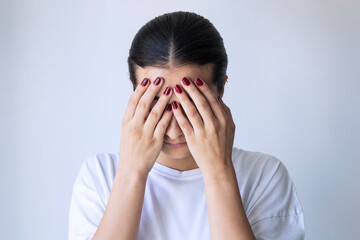 Young girl covering her face with her hands