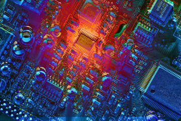 Computer technology risk concept. Hot red virus vulnerability spot on dark blue circuit board abstract background texture