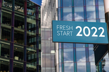 Fototapeta premium Fresh Start 2022 sign in front of city skyscrapers