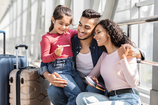 Happy Arab Parents With Cute Little Daughter Waiting For Flight In Airport - Powered by Adobe