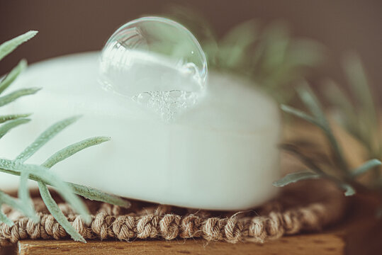 Soap bubble on a bar of soap next to rosemary