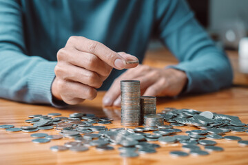 Young man and pile coins to planning growing saving strategy with pile coins for future plan fund...