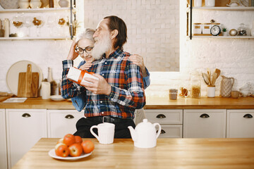 Senior couple with gifts in a kitchen