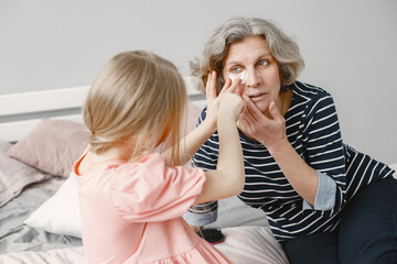 Grandmother spending time with her granddaughter in the bedroom