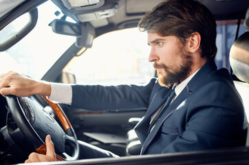 bearded man in a suit in a car a trip to work rich