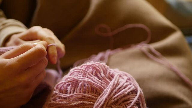 Close up woman knitting woolen sweater with needles. Relaxing hobby. 4k video. Winter holidays craft 
