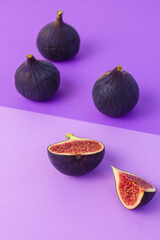 ripe figs and slice of fig on violet and purpure asemetric background