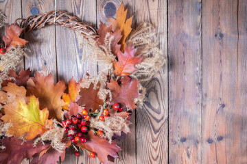 Dried floral wreath from natural materials on dark wooden background. Autumn home decor concept.