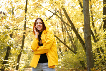 a woman smiles in autumn clothes of yellow leaves in autumn autumn mood. warm autumn weather. walk around the city