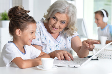 Grandmother and granddaughter shopping online together at home