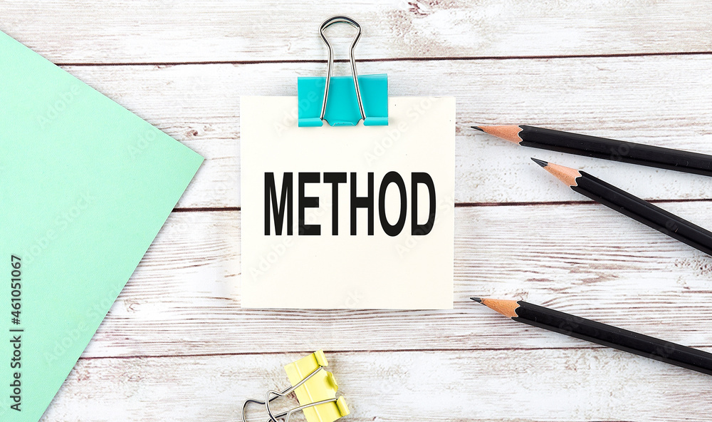 Poster stickers with pencils and notebook with text method on wooden background