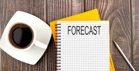 FORECAST text on the notebook with coffee on wooden background