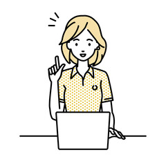 デスクで座ってPCを開いて何かひらめいたポロシャツの女性