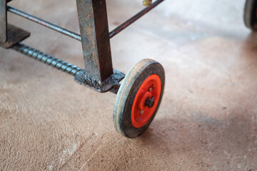 Small rubber wheel of the handyman trolley cart which is used for store some hand tool and service equipment at the garage. Vehicle part object, close-up and selective focus.