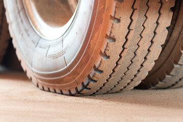 A big wheel of the heavy truck or lorry trailer which is parking on concrete ground. Transportation and vehicle equipment object photo. Close-up and selective focus at type's part.