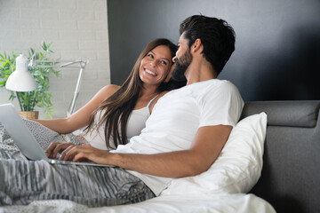 Obraz premium Romantic happy couple in love relaxing at home having fun. People technology concept.