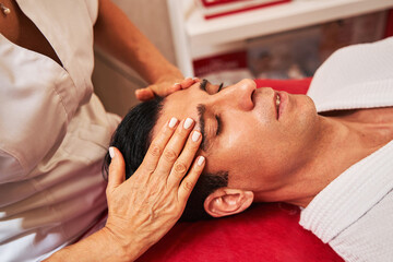 Fototapeta na wymiar Woman is massaging man forehead with hands