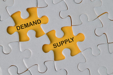 Top view of jigsaw puzzle with text DEMAND and SUPPLY