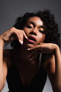 Sexy And Young African American Woman Looking At Camera While Posing On Dark Grey