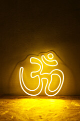 Yellow neon sign OM. Om symbol glow background. Hindu religion. Trendy style. Neon sign. Custom neon. Home decor. Relax vibe.