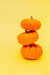 Halloween pumpkins on yellow background. Flat lay, copy space. Happy Halloween Card.