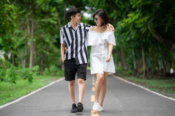 Happy Asian LGBT lesbian couple in love having a good time walking in the park