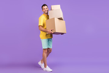 Full body photo of happy cheerful man hold hand boxes smile move houses isolated on purple color...