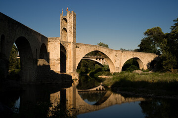 Medieval stone bridge over river at sunset, Besalu Catalonia, Spain