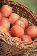 Fresh ripe apples in wicker basket on stall at bazaar