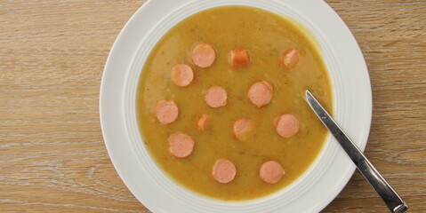fresh potato soup with viennese sausages on a wooden board