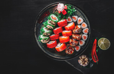 sushi roll in plate on black wooden table background. top view