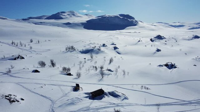 Snowy Landscape With The View Of STF Unna Allakas Mountain Cabin In Kiruna, Sweden - aerial drone shot