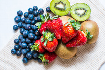 mix of fruits on the table in the central market, strawberries, blueberries, kiwis