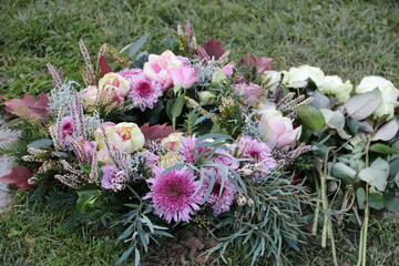 Trauerkranz mit Chrysanthemen und Rosen nach Beerdigung auf dem Friedhof