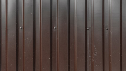 Corrugated metal sheet texture background. Texture of brown metal profiled sheet fence decking. Facing wall or roofing building material intended for use in construction in the construction. Ral 8017