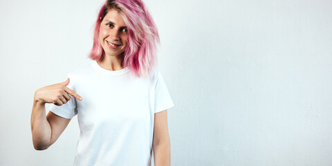 Positive plus size model with white blank t-shirt and pink hear, empty grunge wall background....